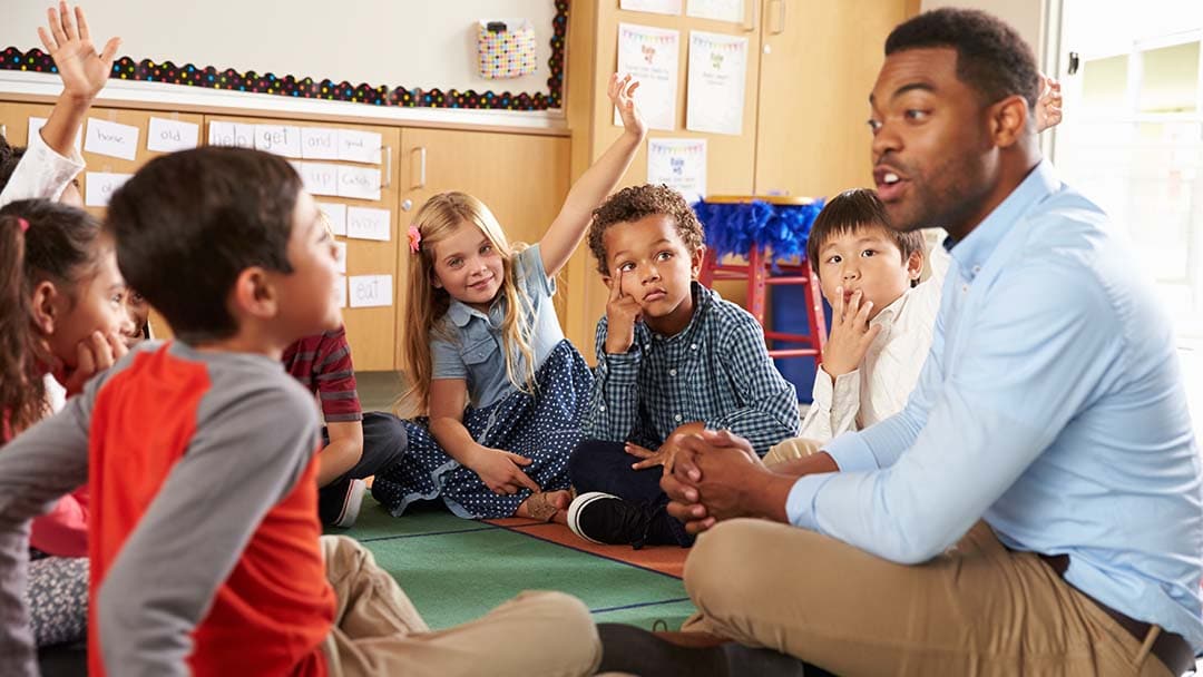 Teacher teaching small group of pupils communication skills